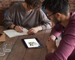 man-wearing-purple-long-sleeved-shirt-looking-at-the-ipad-3184326